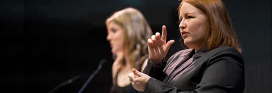 A woman interpreting on a stage.